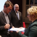 Matthias Schwarz unterschreibt für das FKH die Charta. Rechts Franziska Kopitzsch, Leiterin der Koordinierungsstelle. 